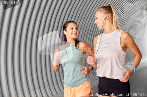 Image of women or female friends with earphones running