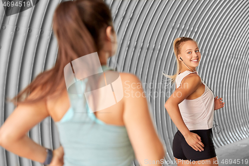 Image of women or female friends with earphones running