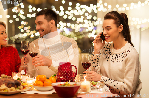 Image of happy friends having christmas dinner at home