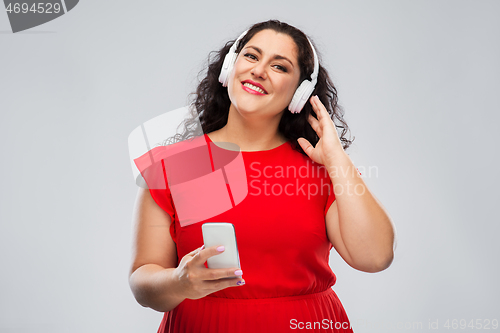 Image of woman in headphones listens to music on smartphone