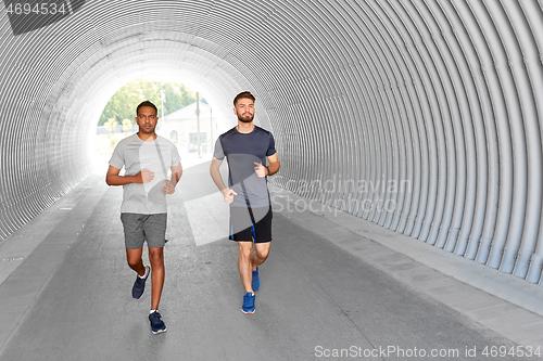 Image of young men or male friends running outdoors