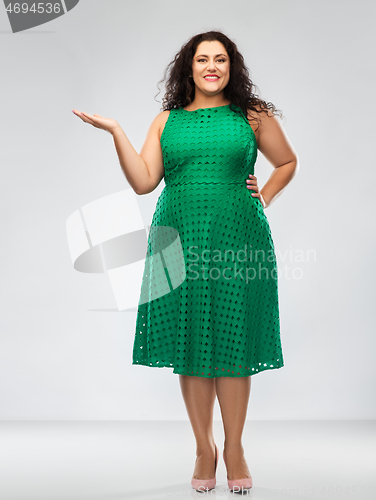 Image of happy woman in green holding something on hand