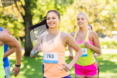 Image of happy young sportsmen racing wit badge numbers