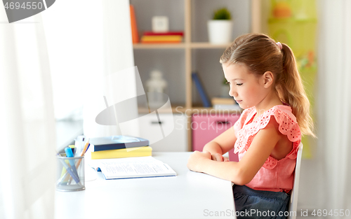 Image of sad student girl with book at home