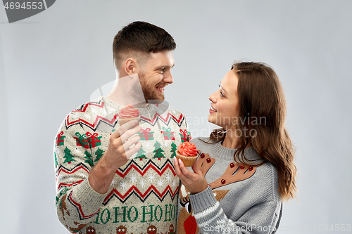 Image of couple with cupcakes in ugly christmas sweaters