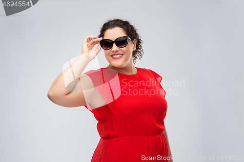 Image of happy woman in red dress and black sunglasses