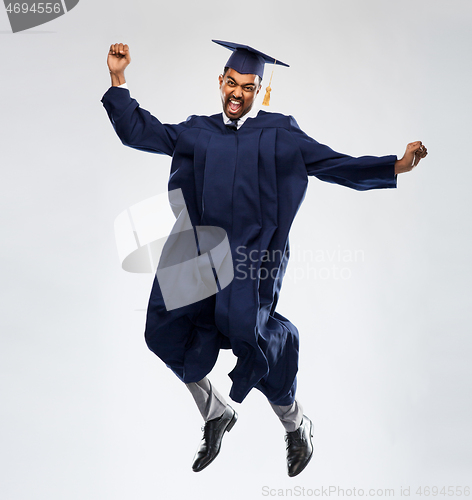 Image of happy male indian graduate student jumping