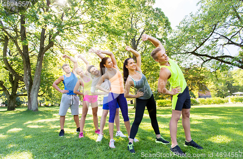 Image of group of happy people exercising at summer park