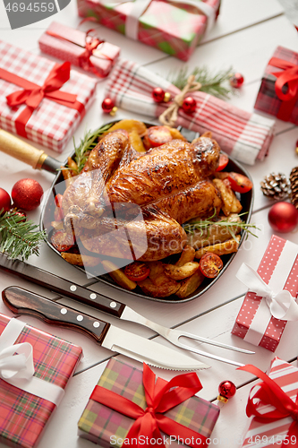 Image of Roasted whole chicken or turkey served in iron pan with Christma