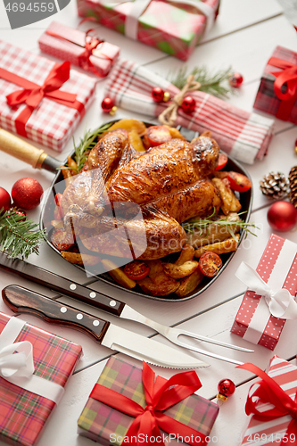 Image of Roasted whole chicken or turkey served in iron pan with Christma
