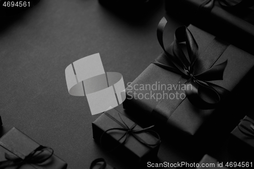 Image of A pile various size black boxed gifts placed on stack. Christmas