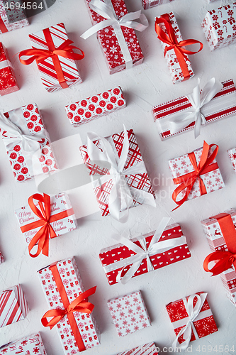 Image of Various pattern and size Christmas boxes placed on white background. Wrapped in festive paper