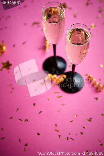 Image of Two glasses full of sparkling champagne wine with golden decoration