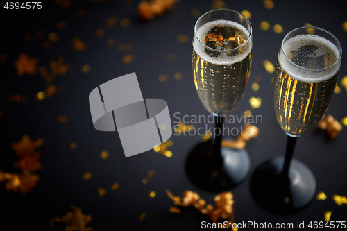 Image of Two glasses full of sparkling champagne wine with golden decoration