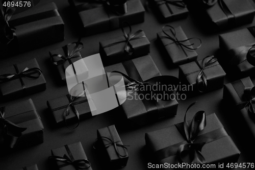 Image of Elegant black Christmas theme. Wrapped gifts in black matte pape