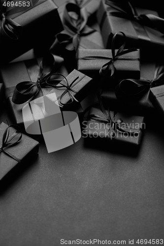 Image of A pile various size black boxed gifts placed on stack. Christmas concept.