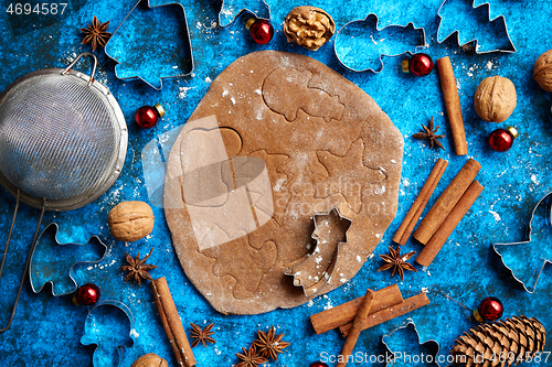 Image of Christmas baking concept. Gingerbread dough with different cutter shapes