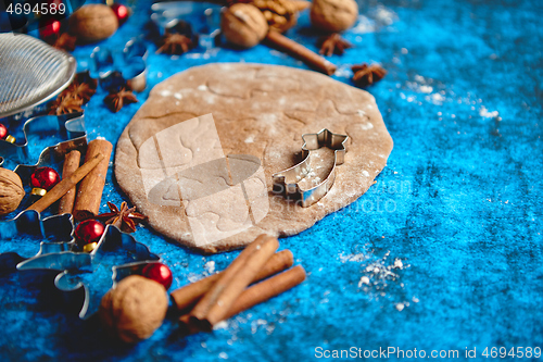 Image of Christmas baking concept. Gingerbread dough with different cutter shapes