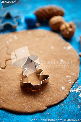 Image of Christmas baking concept. Gingerbread dough with different cutter shapes