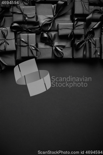 Image of A pile various size black boxed gifts placed on stack. Christmas