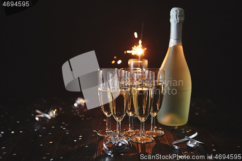 Image of Party composition image. Glasses filled with champagne placed on black table