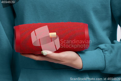 Image of Woman hand holding portable stereo speaker