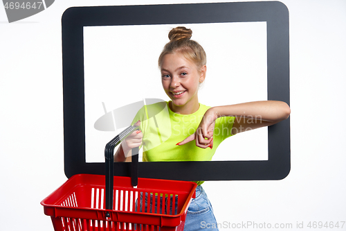 Image of Online shopping concept. Trendy teen girl with empty shopping basket