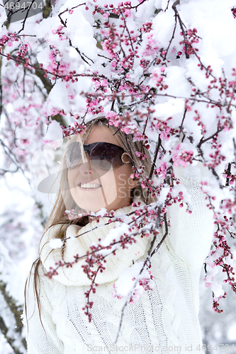 Image of Woman by cherry blossom tree in snow