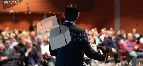 Image of Public speaker giving talk at business event.