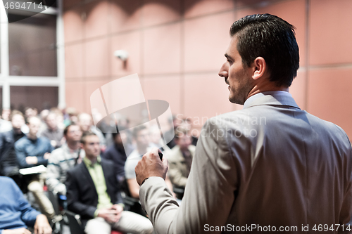 Image of Public speaker giving talk at business event.