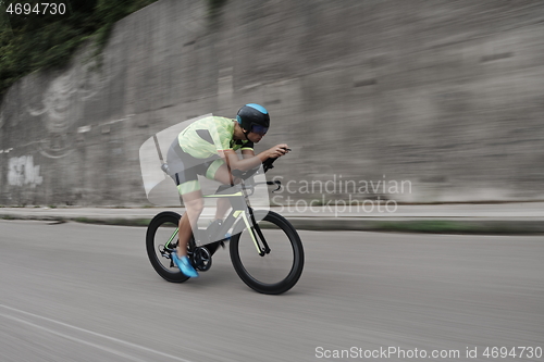 Image of triathlon athlete riding a bike on morning training