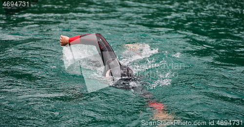 Image of triathlon athlete swimming on lake wearing wetsuit