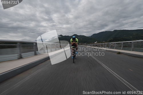 Image of triathlon athlete riding a bike on morning training