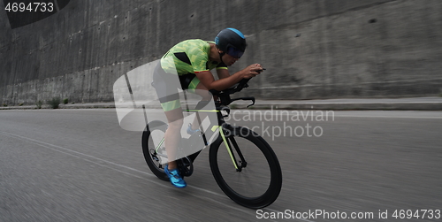 Image of triathlon athlete riding a bike on morning training