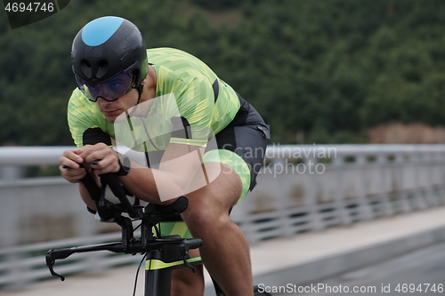 Image of triathlon athlete riding a bike on morning training