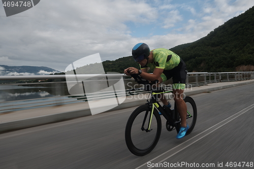 Image of triathlon athlete riding a bike on morning training