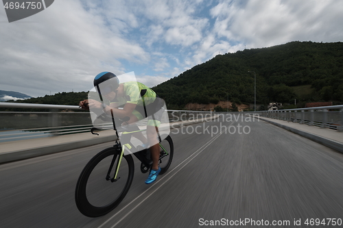 Image of triathlon athlete riding a bike on morning training