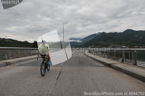 Image of triathlon athlete riding a bike on morning training