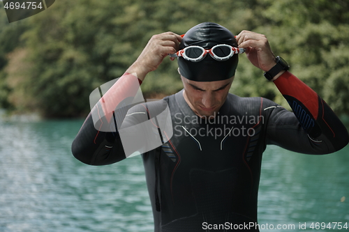 Image of triathlon athlete getting ready for swimming training on lake