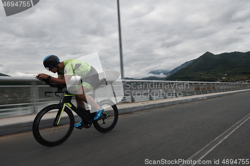 Image of triathlon athlete riding a bike on morning training