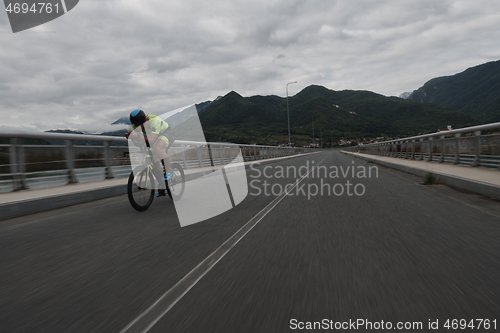 Image of triathlon athlete riding a bike on morning training