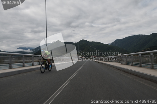 Image of triathlon athlete riding a bike on morning training