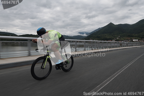 Image of triathlon athlete riding a bike on morning training