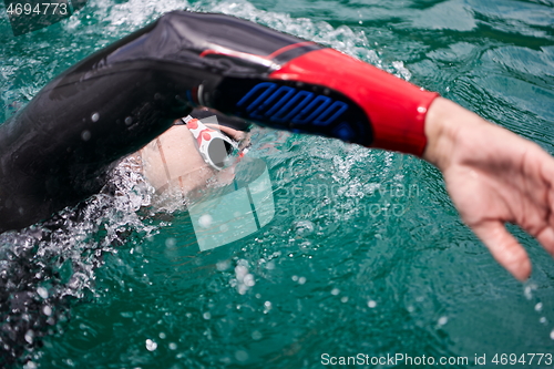 Image of triathlon athlete swimming on lake wearing wetsuit