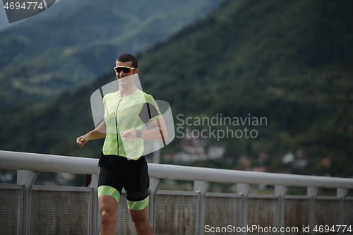 Image of triathlon athlete running on street