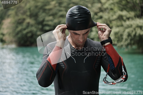 Image of triathlon athlete getting ready for swimming training on lake