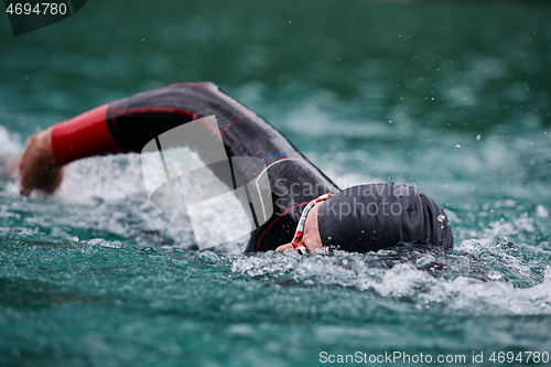 Image of triathlon athlete swimming on lake wearing wetsuit