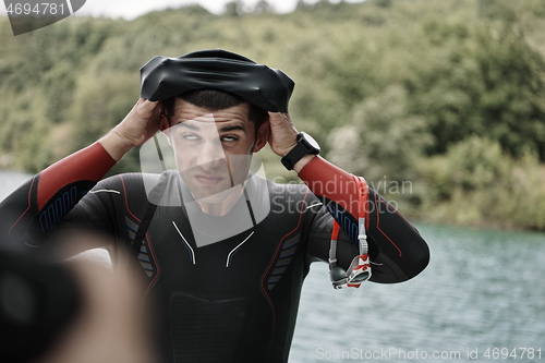 Image of triathlon athlete getting ready for swimming training on lake