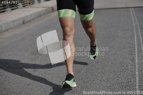 Image of triathlon athlete running on street