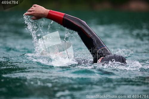 Image of triathlon athlete swimming on lake wearing wetsuit